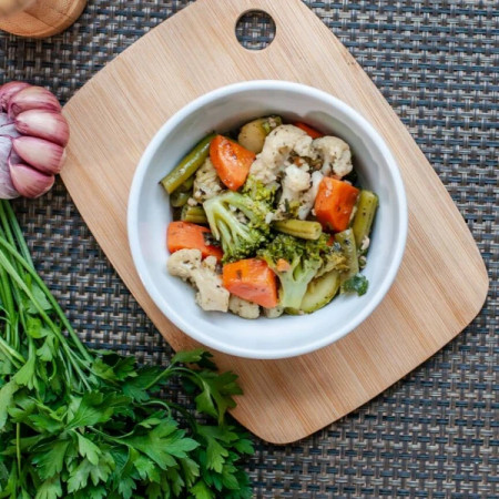 Porção de 200g de legumes variados preparados na manteiga, trazendo um toque cremoso e equilibrado para complementar seu prato com saúde e sabor.