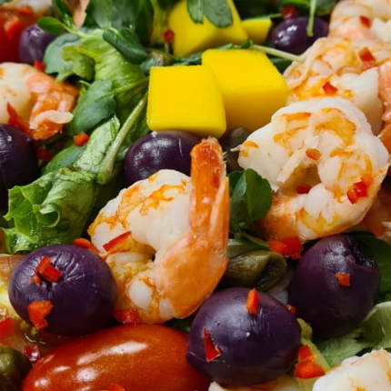 Mix de folhas temperado com azeite e ervas, tomatinhos, queijo parmesão, queijo parmesão e camarões salteados. Molho de iogurte.