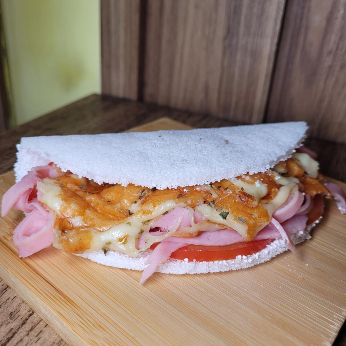 Goma de tapioca artesanal, presunto ,tomate e mussarela finalizada com orégano.