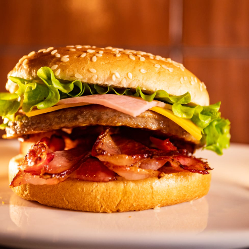 Pão gergelim , carne, queijo , presunto , bacon , maionese temperada , Ketchup , cheddar cremoso e alface .
