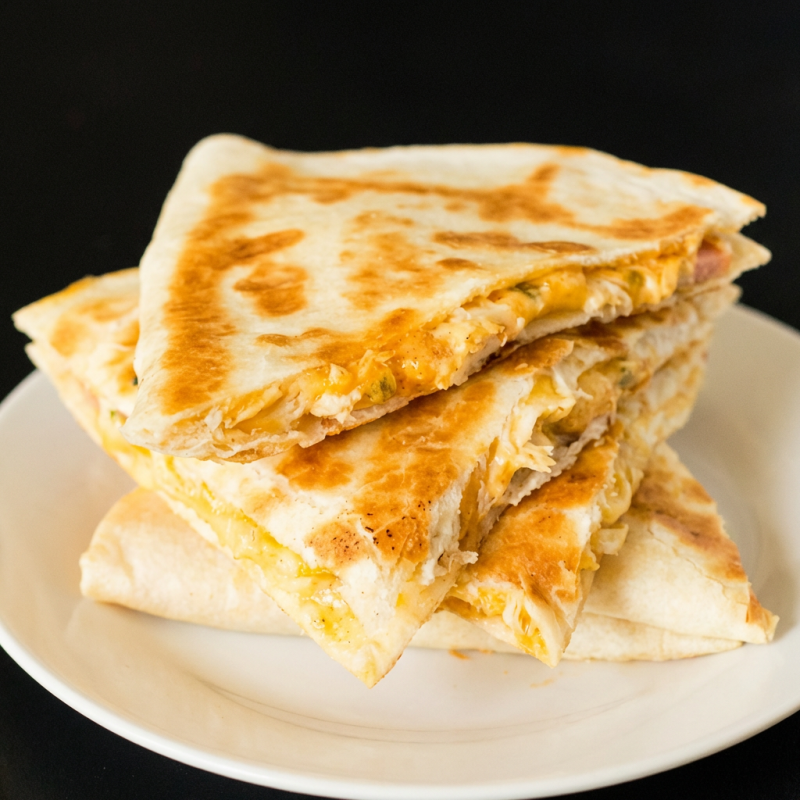 Tortillla de trigo recheada com presunto vegano, queijo tipo mozzarella vegan e tomate Sem pimenta. Para adicionar pimenta selecione no campo complementos para pedir molhos ou pimentas a parte, selecione também o item ""embalagem extra""" Peso médio:120g