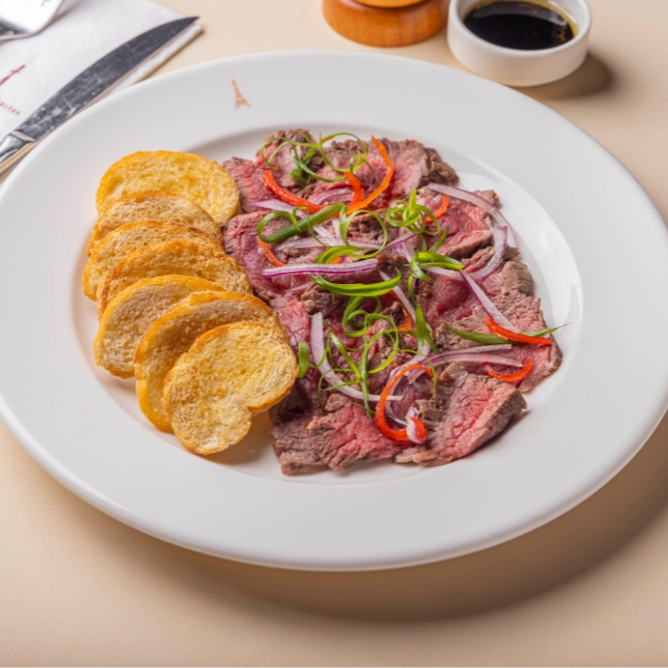 Rosbife macio e suculento, temperado com aceto balsâmico e azeite, acompanhado de torradas crocantes. Opção clássica na gastronomia parisiense.