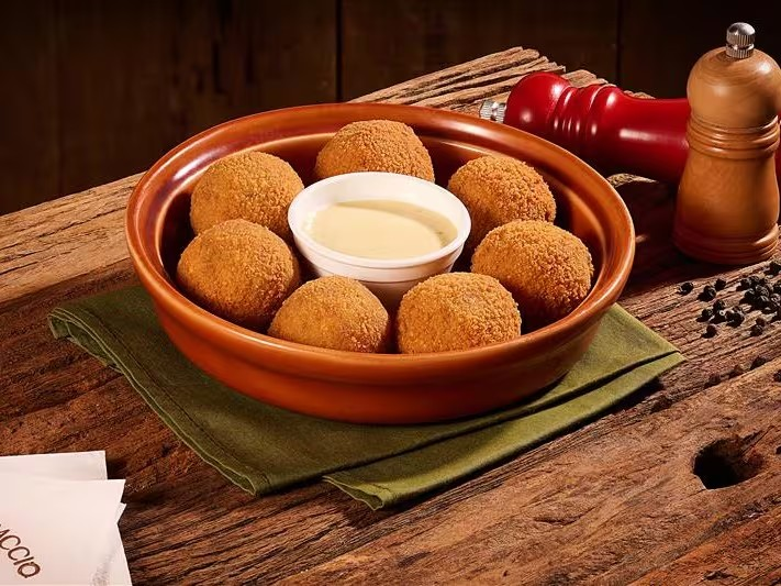 Bolinhos de risotto feitos com arroz arbóreo e pancetta. São crocantes por fora e macios por dentro, acompanhados por um saboroso molho carbonara. *Esse prato leva caldo de frango em sua composição.