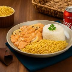 Frango suculento no molho cremoso, arroz soltinho, batata palha crocante e uma Coca bem gelada. Combinação perfeita!