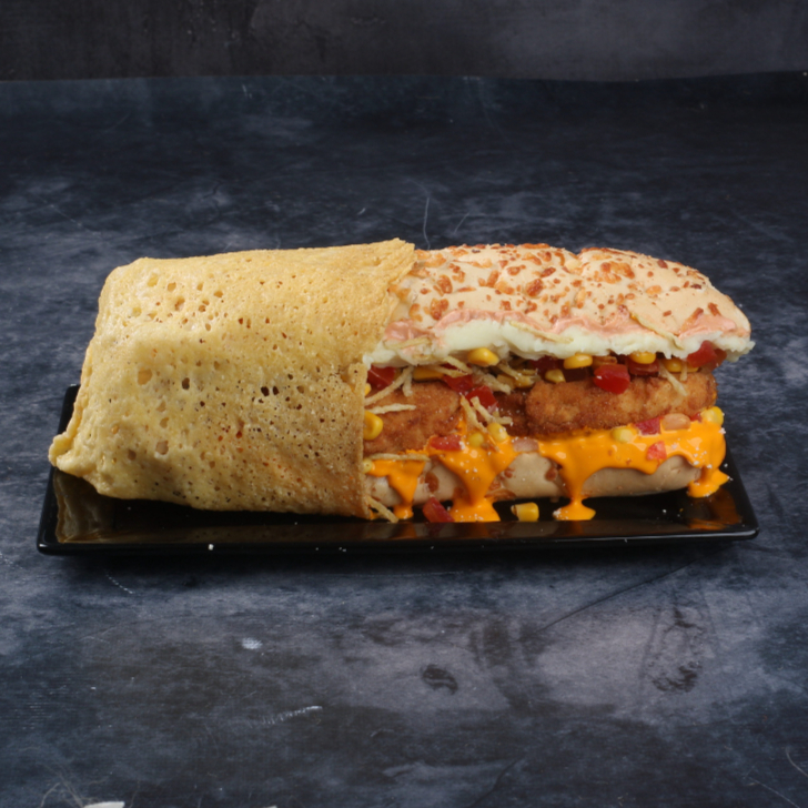 2 tiras de frango empanado, pão baguete (com parmesão), cheddar ou requeijão, milho, vinagrete, batata palha, maionese, purê, orégano, curry e coberto por uma deliciosa crosta de parmesão.