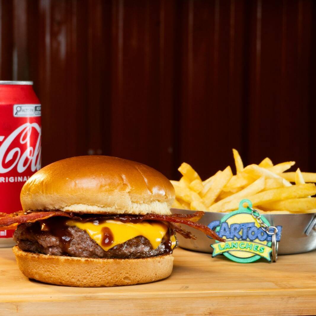 Escalação oficial: Estados Unidos – Edição Exclusiva Da Copa Do Mundo!
O sabor da terra do barbecue entra em campo em uma edição super limitada, disponível apenas durante o período da Copa!
Prepare-se para um verdadeiro campeão de audiência: um suculento hambúrguer de carne artesanal, coberto com muito queijo cheddar derretido, bacon em tiras crocantes e o toque defumado do nosso molho barbecue especial. Tudo isso perfeitamente acomodado no pão da copa. Uma combinação digna de final de campeonato!
Brinde Colecionável: Na compra deste burger da Copa, você ganha um Chaveiro personalizado do Cartoon Lanches!
️ Não deixe para o segundo tempo! Estoques diários limitados enquanto durar o mundial.