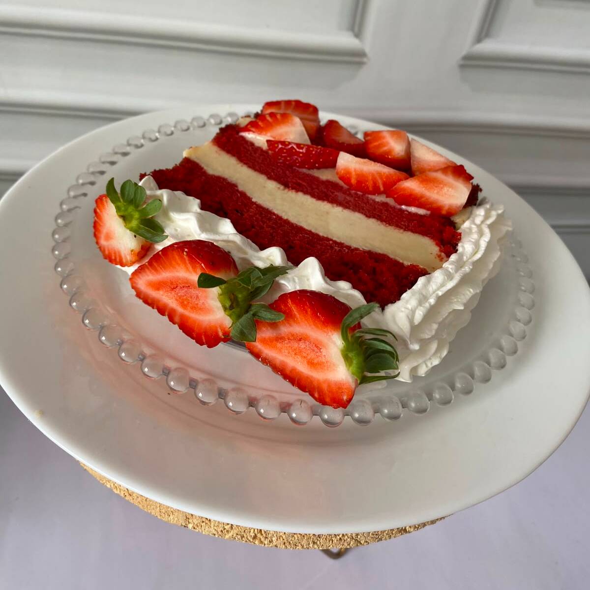 Com uma massa aveludada, leve e úmida. De cor vermelha intensa e sabor suave de chocolate com um toque de baunilha. Com duas camadas generosas de recheios de brigadeiro branco e pedaços de morangos frescos. Coberto com Chantininho e morangos. Irresistível 330 grm