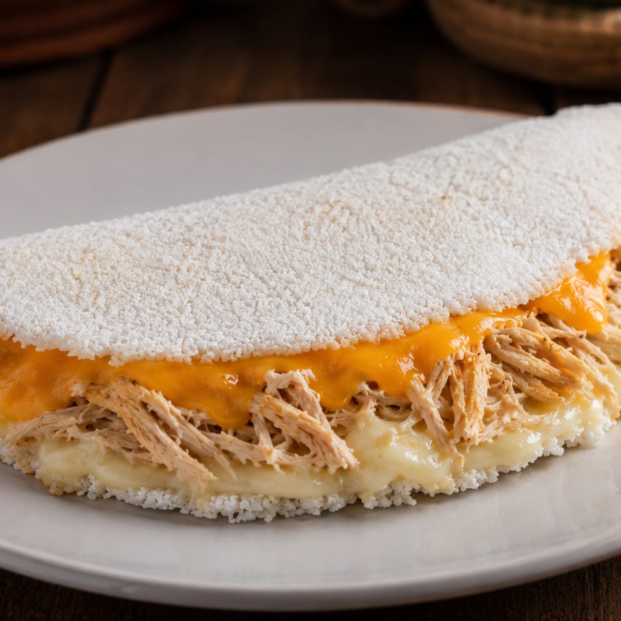 Tapioca quentinha e crocante recheada com frango desfiado no tempero caseiro da casa, coberta com catupiry cremoso e uma camada generosa de cheddar derretido. O encontro dos dois queijos mais pedidos num sabor só. É sucesso garantido!