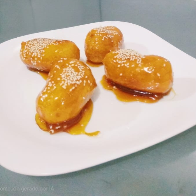 Pedaços de banana empanado e frito caramelizado.