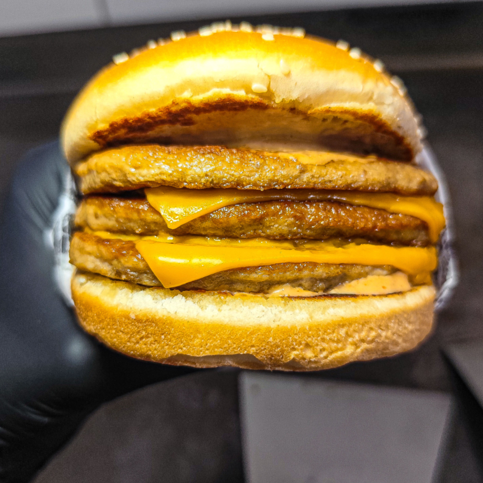 O lanche que não abre mão de mais carne. Pão de gergelim levemente tostado, 3 carnes de 56 g cada, duas fatias de queijo cheddar derretido e nosso molho especial da casa. Cada camada de carne oferece suculência, enquanto o cheddar cria um suave acabamento cremoso, tudo finalizado pelo molho aromático que reforça o sabor completo.
