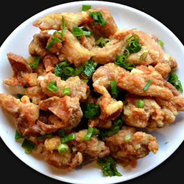 file de coxa frito salpicado com alho e cebolinha.