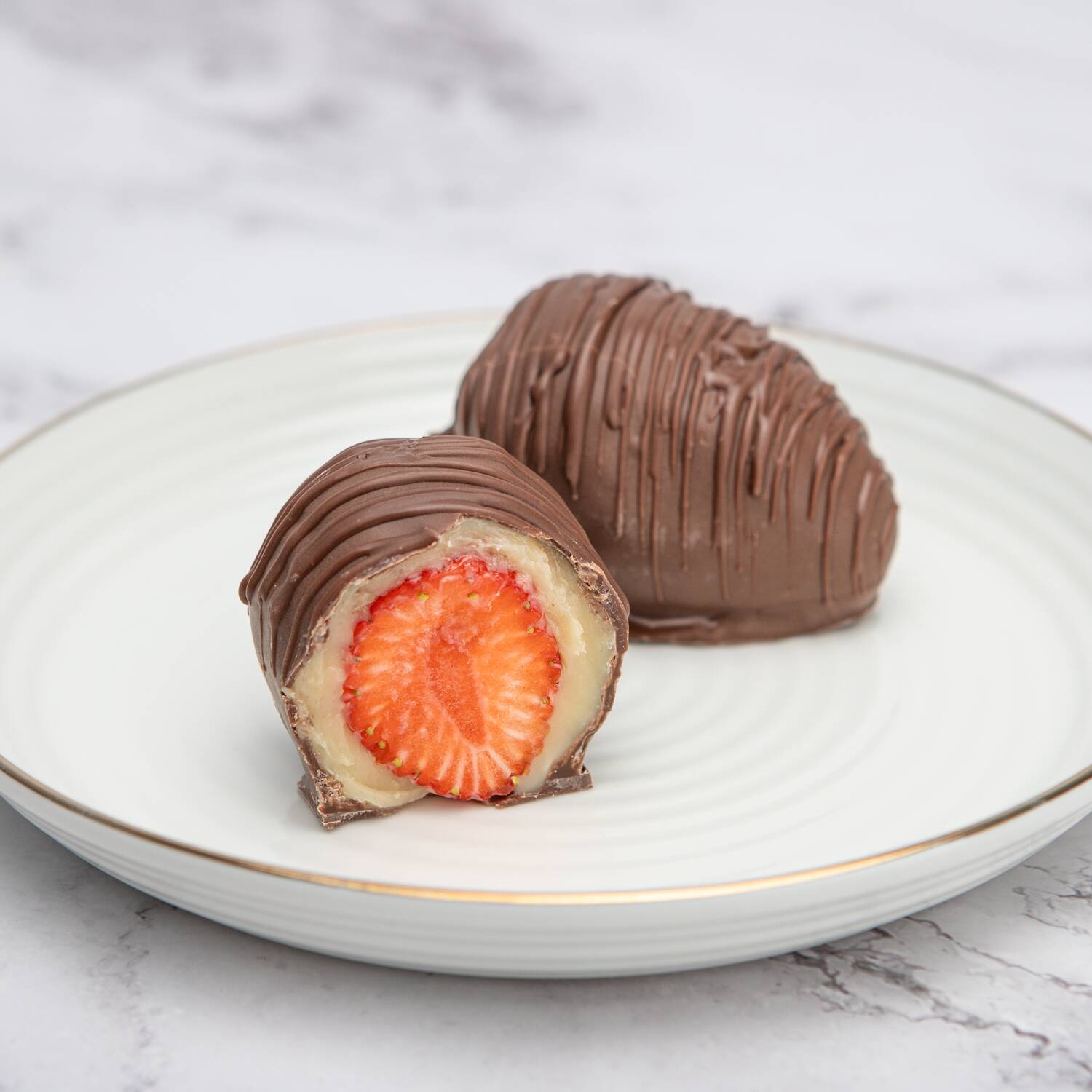 Muito brigadeiro e um morango fresquinho no centro, banhado no chocolate.