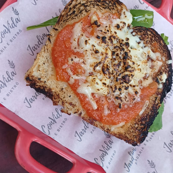 Pão de Brioche com Molho de tomate da casa e muçarela gratinada. Por cima tomate e rúcula frescos