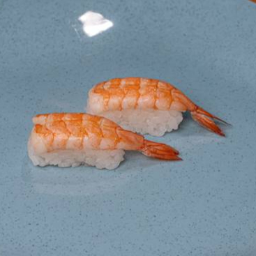 Lâmina de salmão sobre porção de arroz.