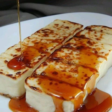 Apresentamos nosso 'Queijo Coalho', uma estrela da nossa categoria 'Petiscos Irresistíveis'. Este delicado queijo é cuidadosamente maçaricado até atingir o ponto perfeito de derretimento. A sutileza do orégano harmoniza de maneira incrível com o sabor marcante do queijo, enquanto o melaço adiciona uma nota adocicada, contrastando e equilibrando todos os sabores. É o aperitivo perfeito para quem busca uma experiência gastronômica única e inesquecível.