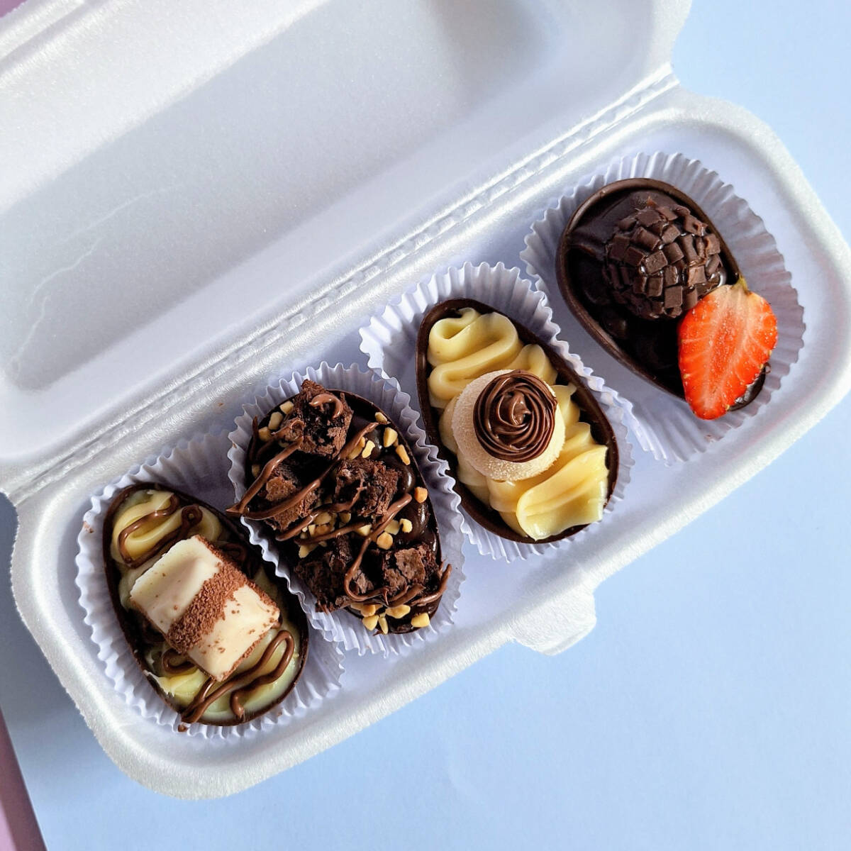 4 mini ovos de 50g cada. Sendo os sabores kinder bueno, brownie com amendoins, ninho com nutella e brigadeiro com morango.