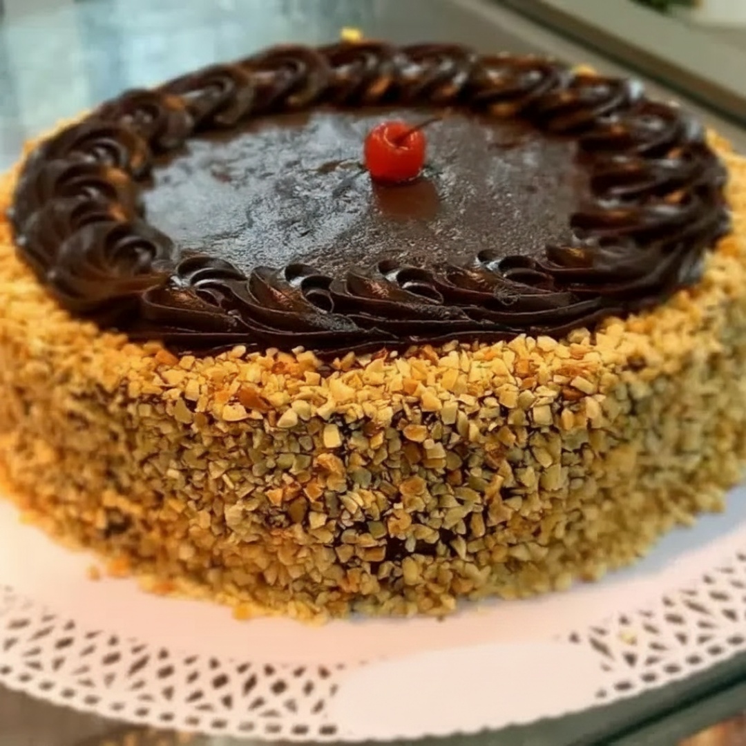 Massa de pão de ló toda preta, duas camadas de recheio de chocolate com amendoim, chocolate e amendoim em volta , tamanho aproximadamente 26cm.