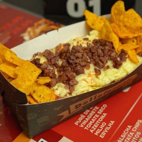 Pão Brioche, Molho Barbecue, Salsicha, Bacon, Batata Palha, Tomate Seco, Cheddar, Azeitona, Muçarela, Ketchup, Maionese, Mostarda (Acompanha Batata Chips)