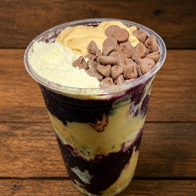 Açaí super cremoso montado em camadas leite em pó, creme de amendoim e gotas de chocolate