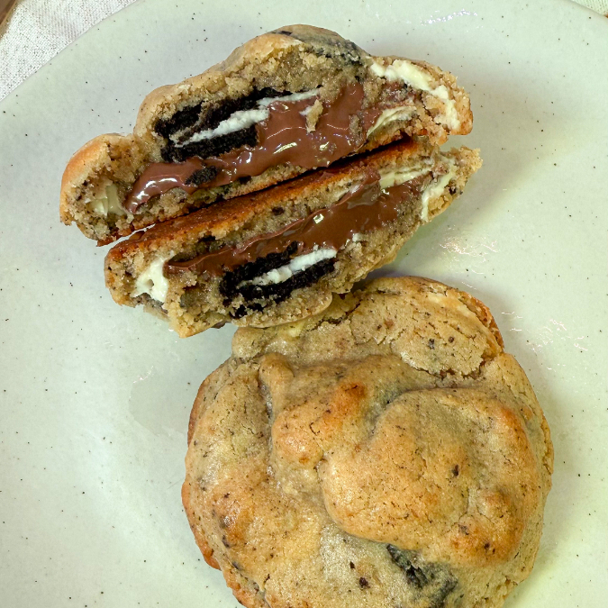 Cookie de massa tradicional com gotas de chocolate branco e pedaços de Oreo na massa, recheado com Nutella e Oreo. Cremoso, generoso e cheio de sabor do começo ao fim. 90g
