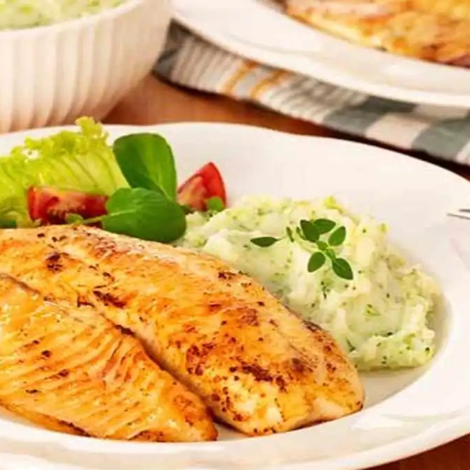 Filé de tilápia fresco, grelhado na perfeição, levemente temperado com ervas e limão, servido com arroz soltinho e purê de batata cremoso.