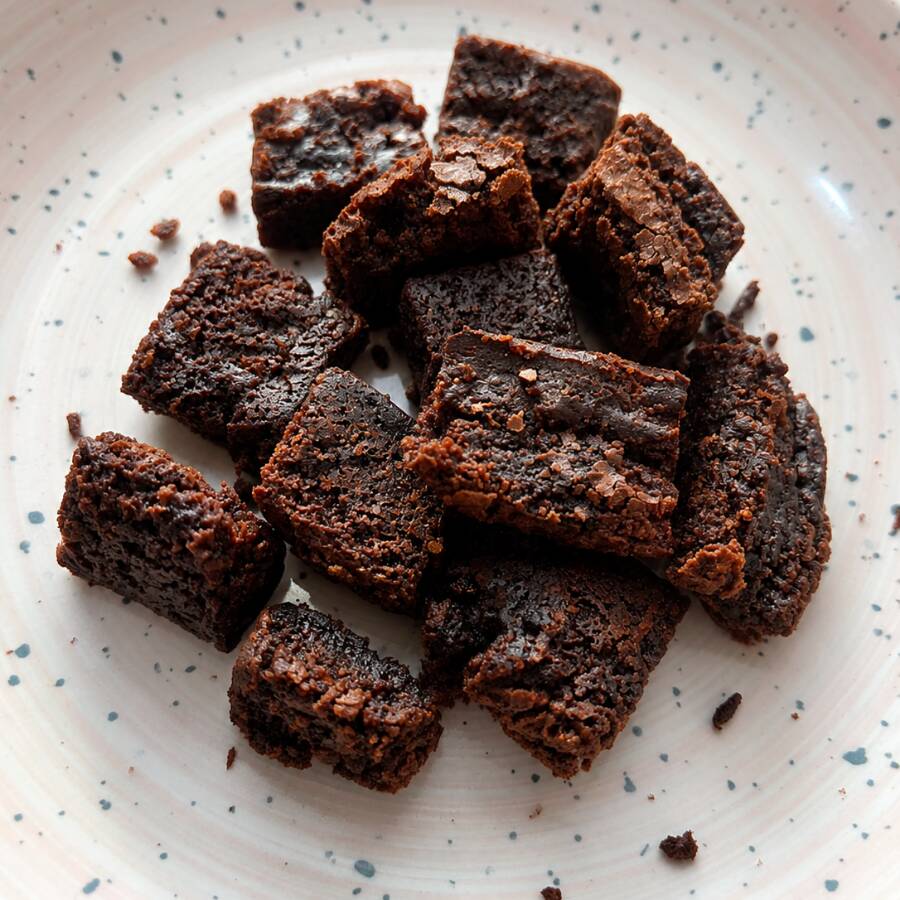 Bordinhas dos nossos brownies. Massa padrão dos brownies artesanais, porém com textura mais firme por serem bordinhas. São embaladas nos saquinhos de brownies e têm aproximadamente 60g.