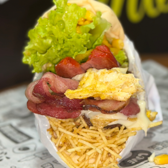 Pão, hamburguer, salsicha, calabresa, bacon, ovo, presunto, mussarela, alface, tomate, milho, batata, catupiry e abacaxi.