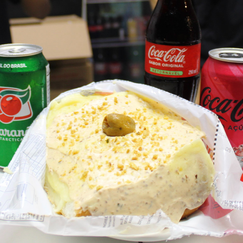 Pão, salsicha, ketchup e mostarda, vinagrete sem cebolas, milho, batata palha, purê de batatas maravilhoso, Maionese hellmans temperada com pate de azeitonas pretas, Calabresa fatiada ao molho de tomates italianos, alho frito e uma azeitona.