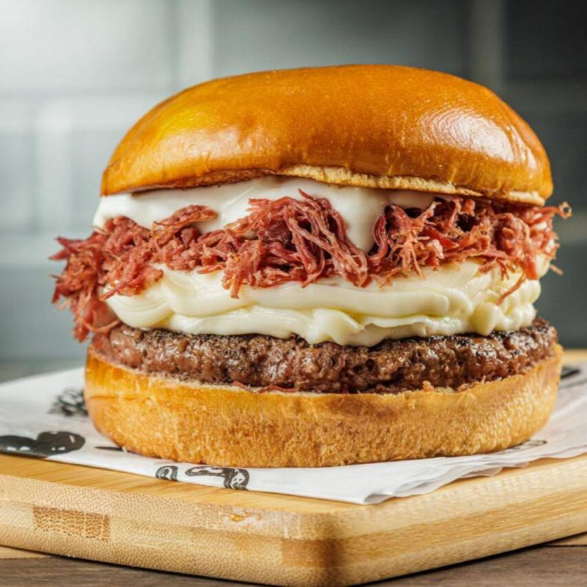 Pão brioche, Blend Angus 160g na brasa, queijo coalho, cream cheese, charque desfiada, cebola caramelizada e maionese da casa.