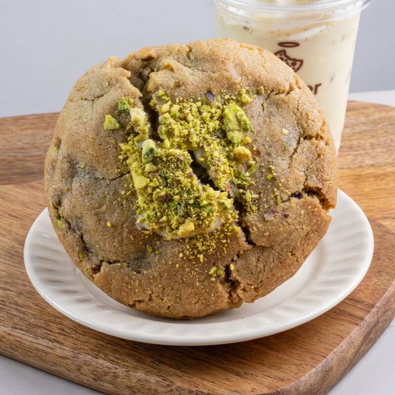 Pistache, pistache e mais pistache. Pedaços generosos de pistache na massa, recheio de creme puro de pistache, e finalizado com pistache por cima. Para adicionar uma doçura suave e equilibrada, um toque de chocolate branco na composição, criando uma combinação harmoniosa e deliciosa. Não tem como não amar!