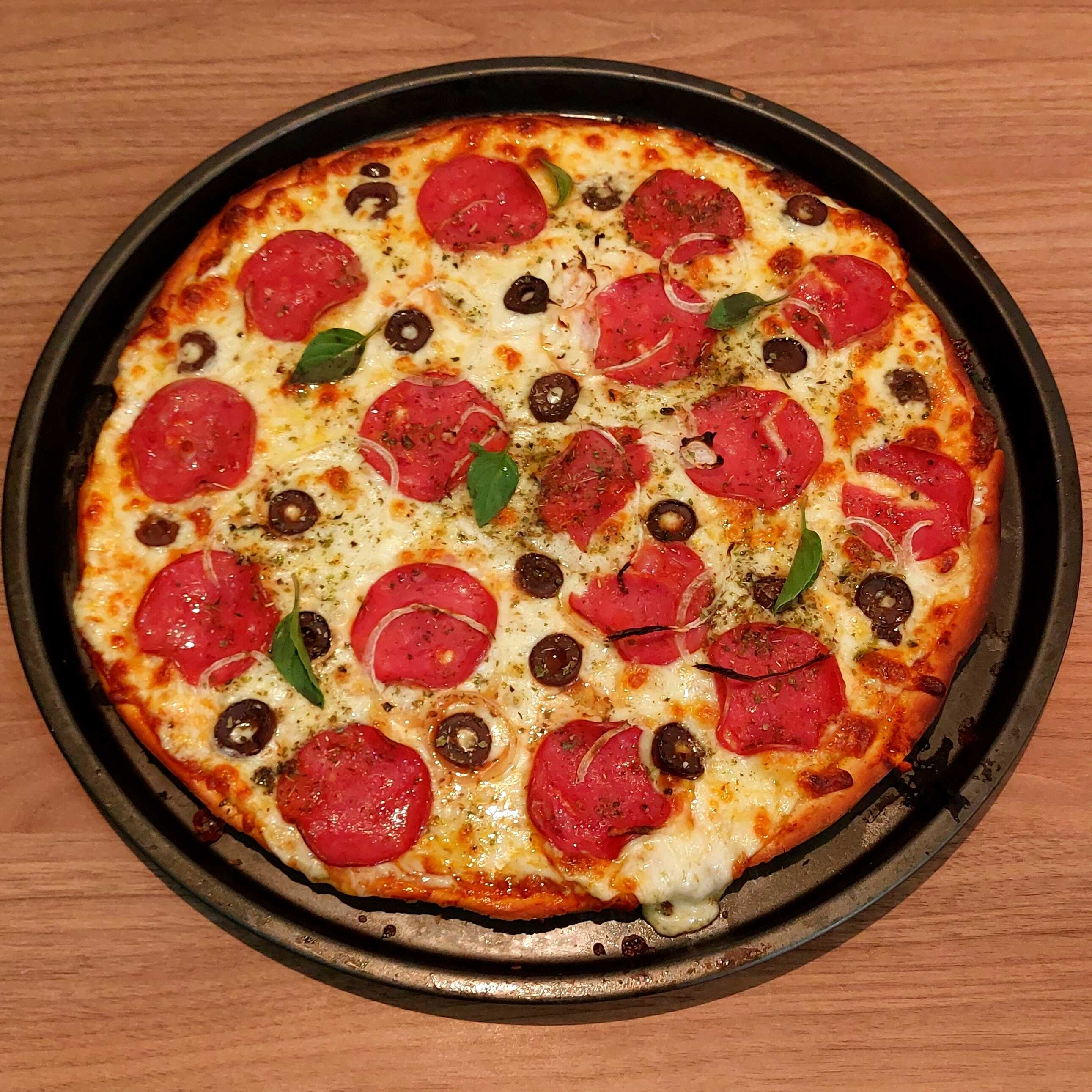 Deliciosa Pizza com fatias de Calabresa, Cebola e Azeitonas Pretas, além de um molho de tomates feito Artesanalmente na casa e Queijo Muçarela.