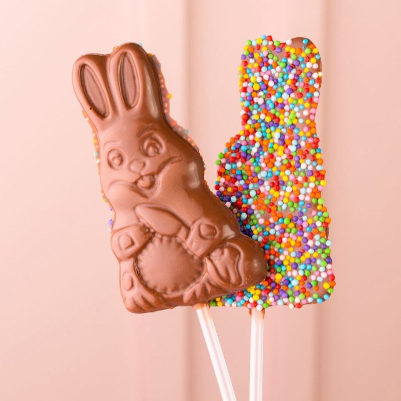 Pirulito de chocolate nobre ao leite, em formato de coelho, decorado com dragê colorido. Uma opção delicada e encantadora para a Páscoa!