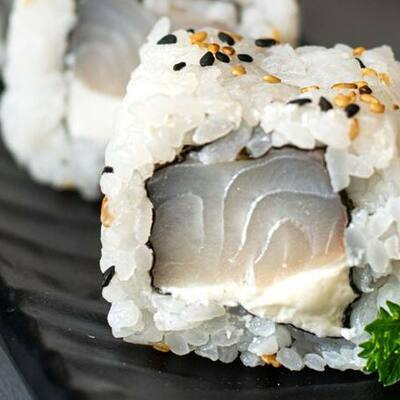 porçao com 10 unidades de uramaki com recheio de peixe branco e cream cheese.