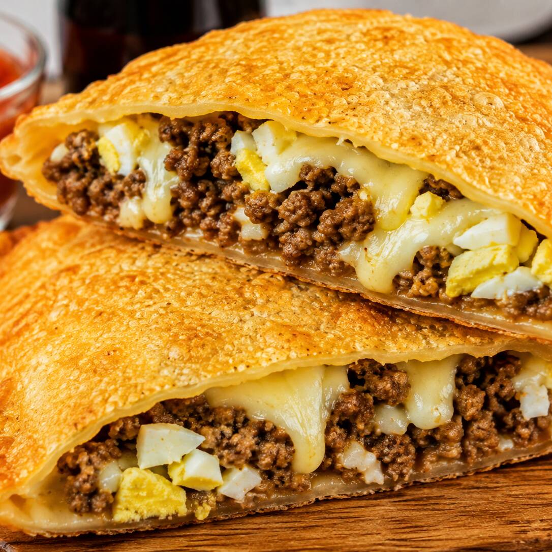 Carne moída bem temperada e suculenta, queijo derretido e ovo, juntos em um recheio generoso e cheio de sabor. Tudo envolvido em uma massa sequinha, crocante e douradinha. Um pastel completo, caprichado e irresistível! 🤤