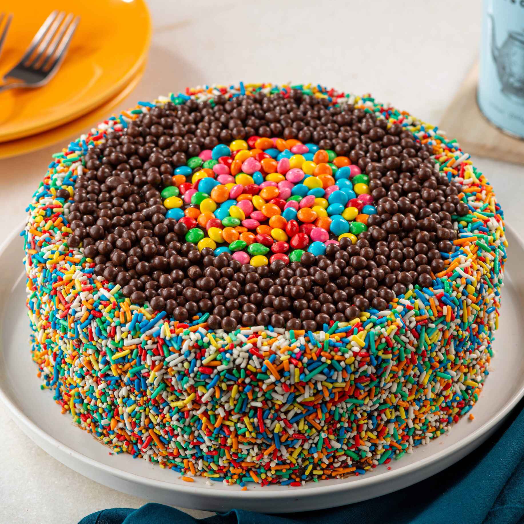 Bolo de chocolate caseiro, com recheio de brigadeiro cremoso, coberto com ganache de chocolate, decorado com granulado, bolinhas e confetes de chocolate. Imagem meramente ilustrativa.