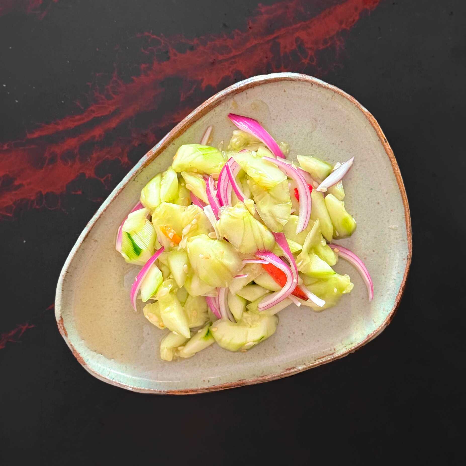 Nível: Para quem quer uma explosão de crocância e refrescância! 🥒🌶️
O irmão do Som Tum que você precisa conhecer! O Tam Teng é a famosa e refrescante salada tailandesa de pepino, levemente pilado para absorver todo o sabor do nosso molho especial. Combinamos Pepino suculento e crocante com Cebola Roxa fatiada e Pimenta fresca, envolvidos em um molho artesanal agridoce e umami feito com molhos e temperos importados da Tailândia como molho de Tamarindo, Molho de Peixe (Nam Pla) e mais! O equilíbrio perfeito entre o cítrico, o salgado, o adocicado e o picante.