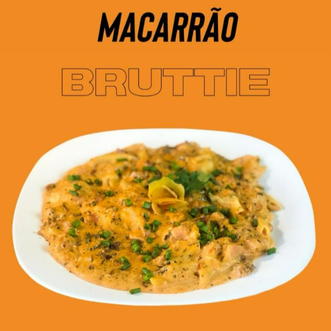O Macarrão Bruttie 500gr é um prato excepcional da categoria 'Macarrões'. Compreende uma massa deliciosamente cozida, generosamente regada com um molho branco cremoso e um molho vermelho intensamente saboroso. Acrescenta-se a isso um frango desfiado suculento, bacon crocante e presunto de sabor inconfundível. A mussarela derretida e as azeitonas adicionam uma camada extra de sabor, enquanto o alho, a cebola e a cebolinha proporcionam um aroma irresistível. Para finalizar, o prato é polvilhado com orégano e nosso tempero especial da casa, que eleva este prato a um novo patamar de delícia. Uma experiência culinária verdadeiramente memorável.