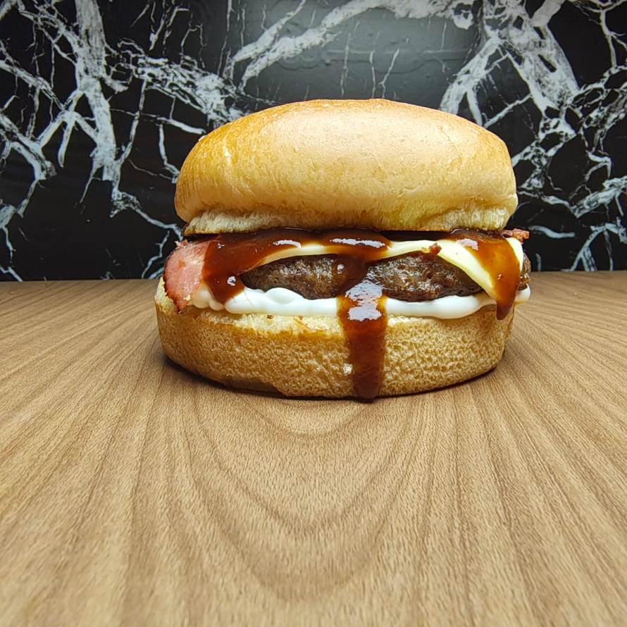 Pão Brioche ,Molho Grill, Carne Artesanal ,Mussarela, Fatias De Bacon .