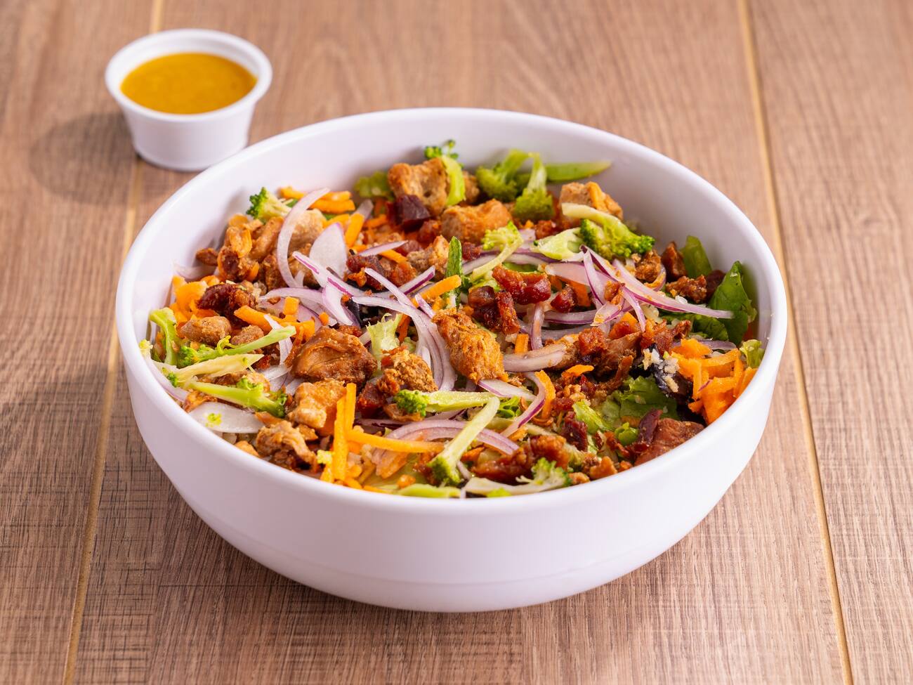 Mix de folhas, arroz de couve flor, frango grelhado, brocolis, cenoura, cebola, crispy tempura, bacon. Molho: mostarda e mel