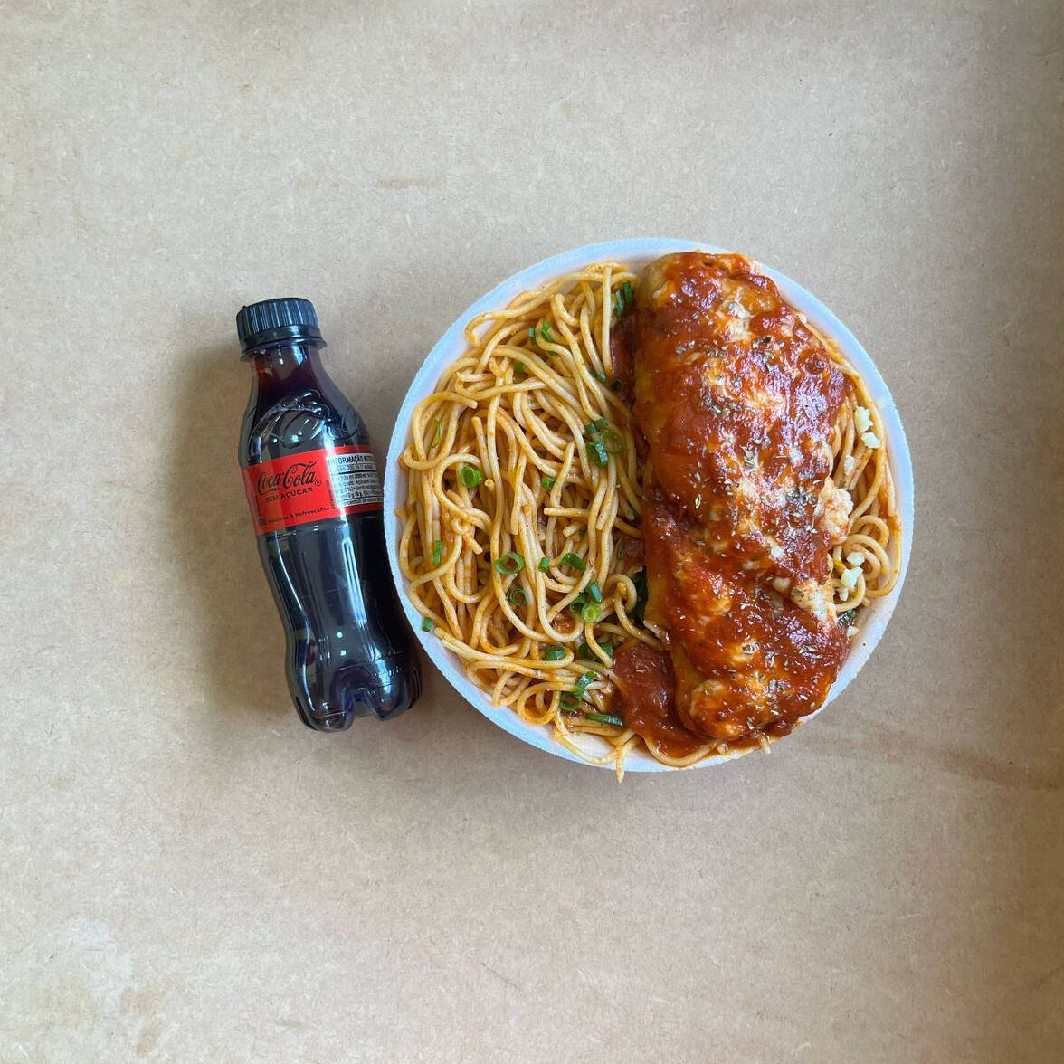 Marmita com delicioso filé de frango parmegiana (empanado na massa crocante coberto com molho de tomates e queijo) acompanhado de macarrão espaguete ao molho de tomates. Acompanha refrigerante pet Coca Cola Zero sem açúcar bem gelado. Marmita indicada para 01 pessoa.