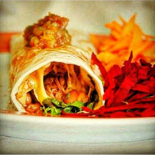 Tortilla de trigo recheada com queijo derretido, alface em tiras, tomate picado e feijão mexicano.