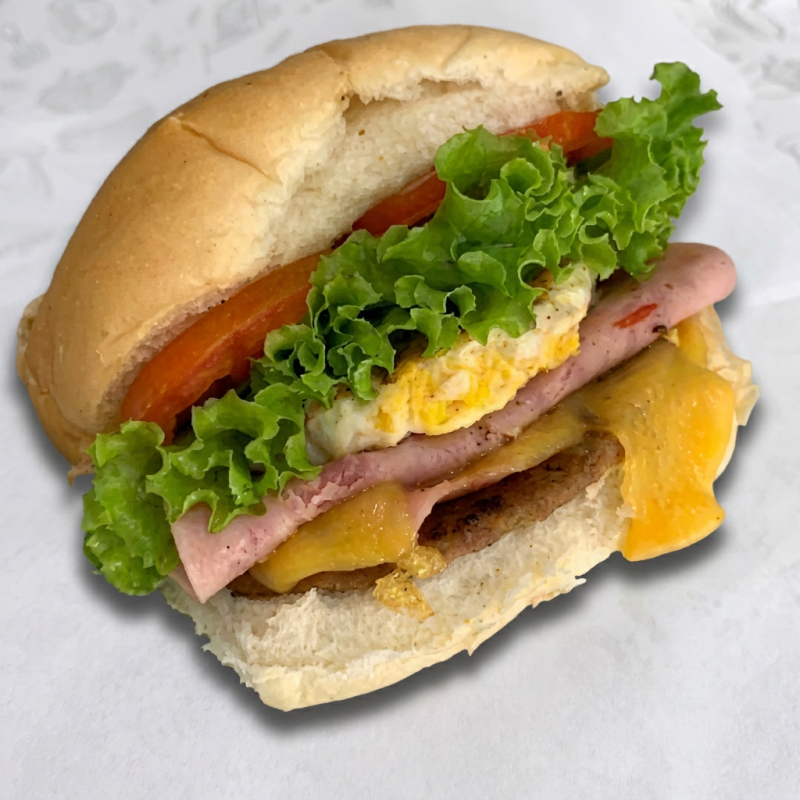 Delicie-se com o nosso 'Americano', um prato da categoria 'Lanches na Chapa'. Este lanche incrivelmente saboroso é composto por pão crocante e fresco, queijo suavemente derretido, presunto de primeira qualidade, um ovo cuidadosamente frito para a perfeição, alface crocante e tomate maduro e suculento. Uma combinação clássica e irresistível que certamente agradará o seu paladar.