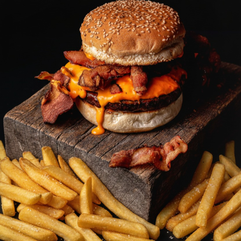 Hambúrguer suculento de carne bovina, com maionese da casa, cheddar derretido e tiras crocantes de bacon no pão brioche. Acompanha porção de batata frita (220g) pra completar o combo perfeito!