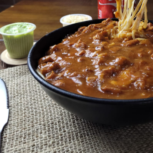 Macarrão tipo espaguete, molho vermelho, carne moída e molho especial