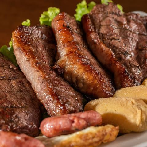 Fatia de cupim grill na chapa, 1 sobrecoxa, 1 toscana, arroz temperado, feijão tropeiro, salada vinagrete, farofa.