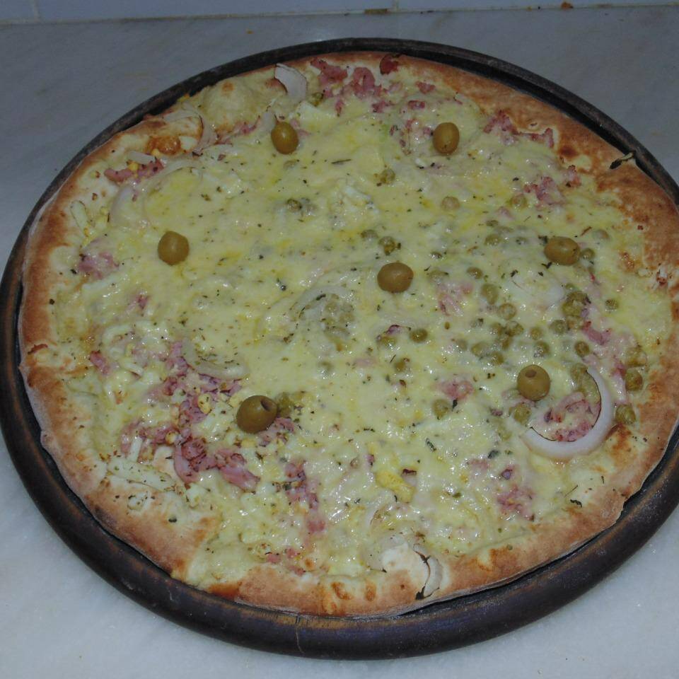 Pizza clássica com molho de tomate, presunto, cebola, azeitonas, ovos e queijo mussarela.