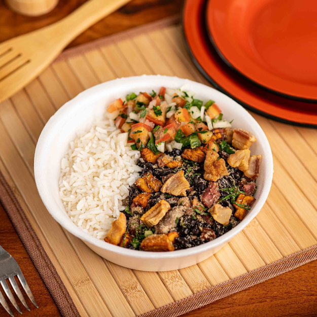 Feijão tropeiro com carne suína em cubos, linguiça calabresa, torresmo crocante, banana caramelizada, ovo mexido e couve fresca. Acompanha arroz branco soltinho e um vinagrete.