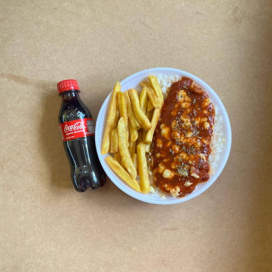 Marmita com delicioso filé de frango parmegiana (empanado na massa crocante coberto com molho de tomates e queijo) acompanhado de arroz branco e batatas fritas. Acompanha refrigerante pet Coca Cola bem gelado. Marmita indicada para 01 pessoa.