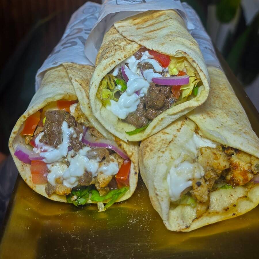 Pão sírio, iscas de carne e frango bem temperado e macio, tomate, alface, cebola roxa e um delicioso molho de alho artesanal.