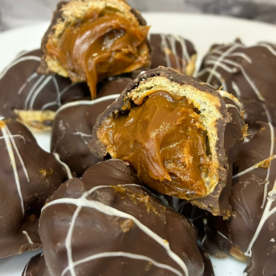 Carolinhas recheadas com doce de leite cremoso e aveludado, envolvidas pela massinha delicada que derrete na boca a cada mordida. Doces na medida certa e simplesmente irresistíveis — a porção tem aproximadamente 100g, equivalente a cerca de 2 unidades perfeitas para se deliciar!